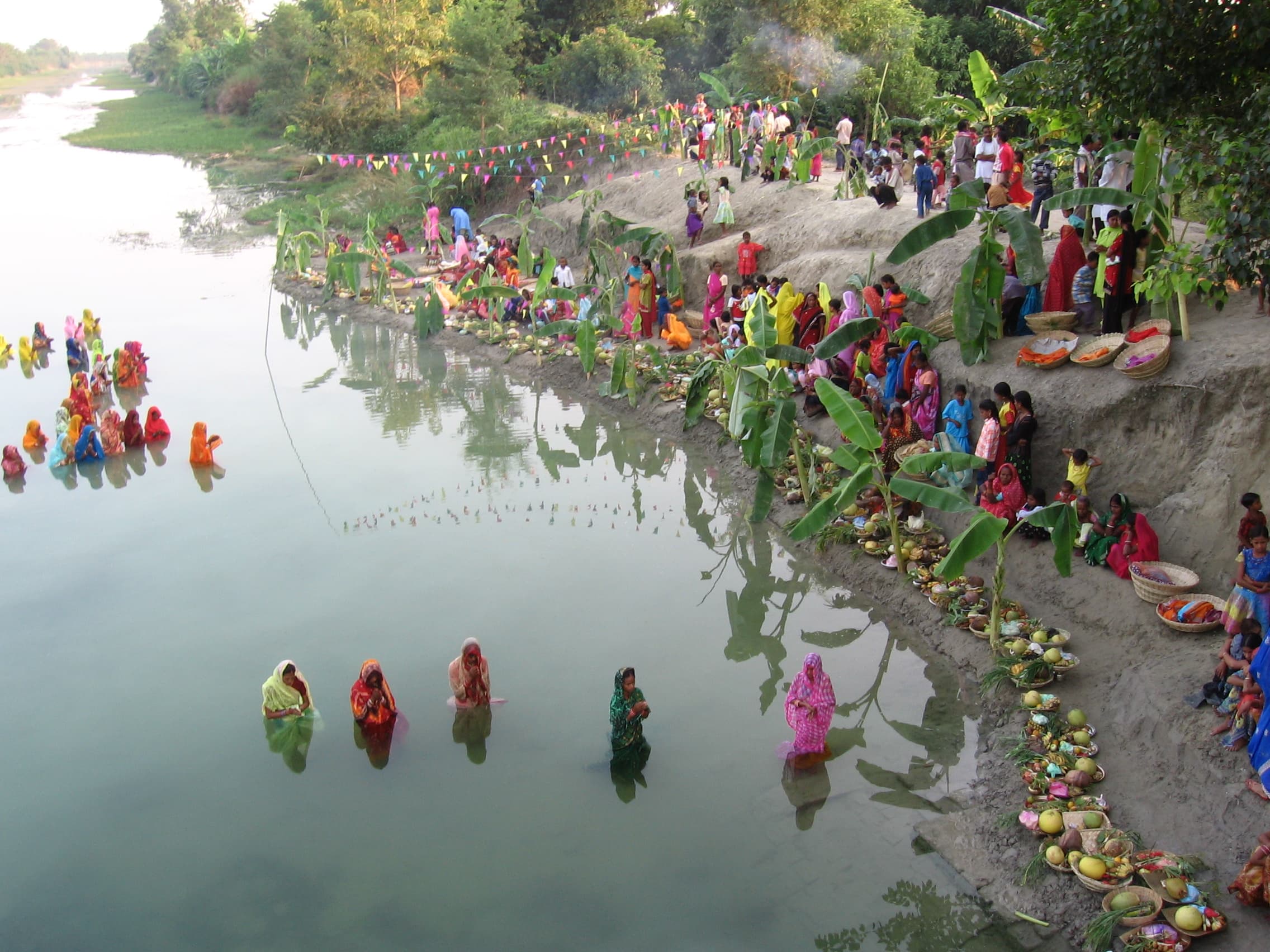 Families gathered beside a village water body in Bihar during Chhath Puja