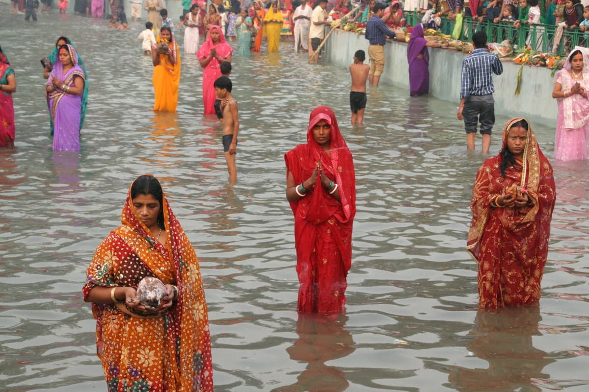 Devotees standing in water during Sandhya Arghya at Chhath Puja